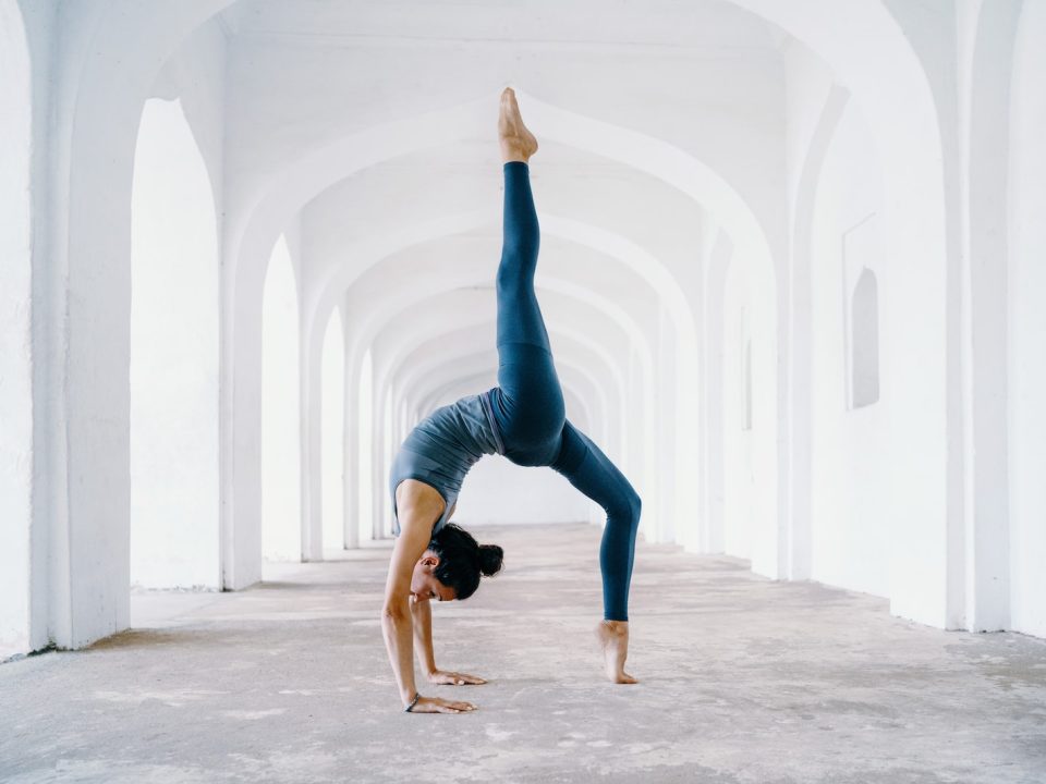 woman in blue leggings and black tank top doing yoga